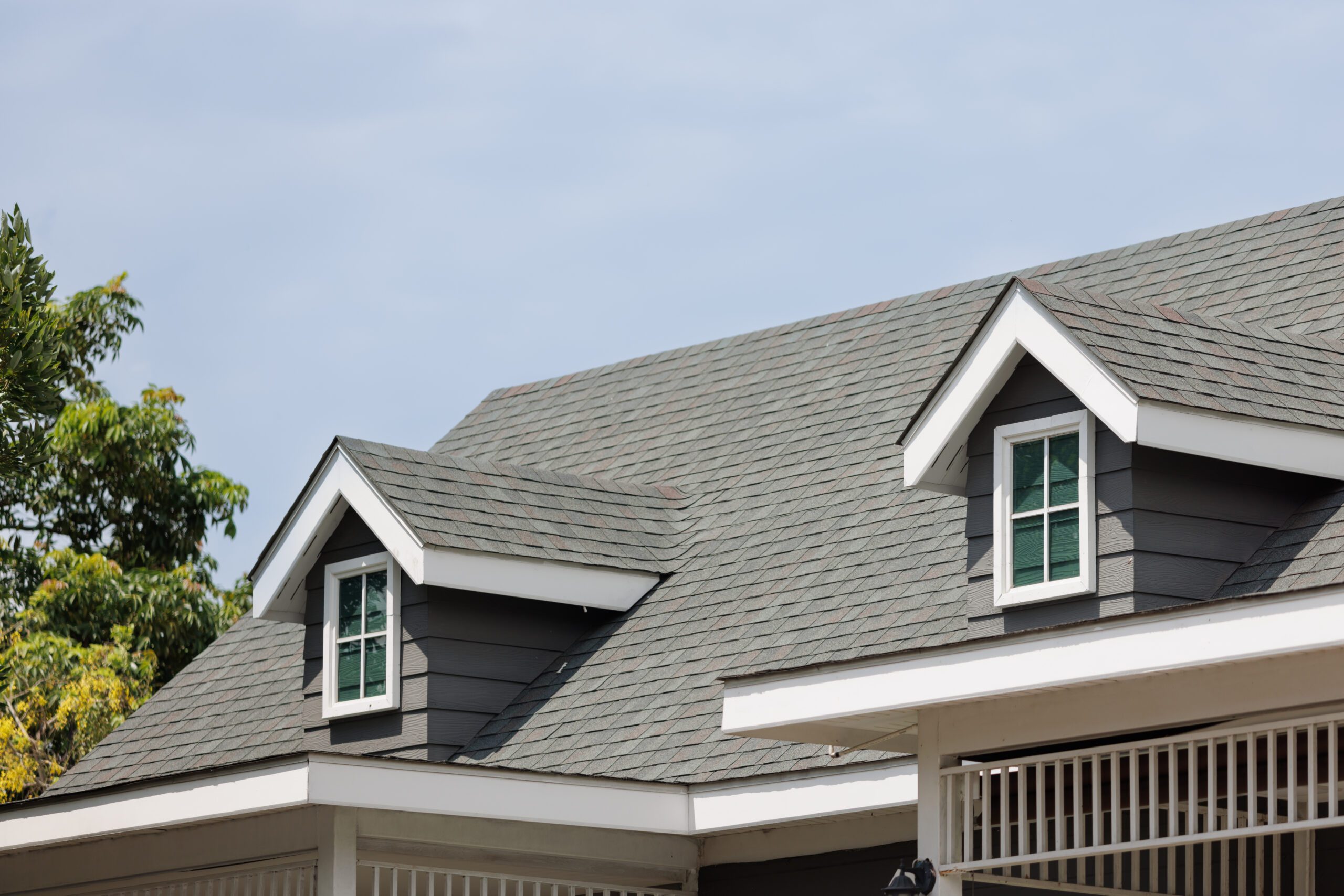 Roof shingles with garret house on top of the house. dark asphalt tiles on the roof background on afternoon time. dark asphalt tiles on the roof background Roof shingles with garret house on top of the house. dark asphalt tiles on the roof background on afternoon time. dark asphalt tiles on the roof background
